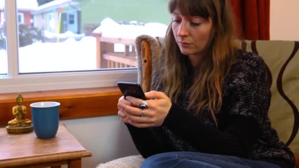 リビングルームで携帯電話を使う女の子 — ストック動画