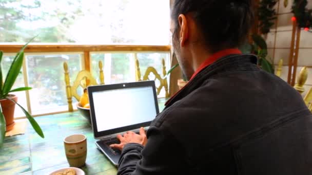Mann am Tisch arbeitet mit Laptop — Stockvideo