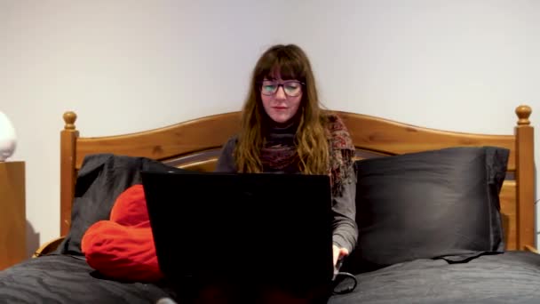 Ragazza sul suo computer portatile in camera da letto . — Video Stock