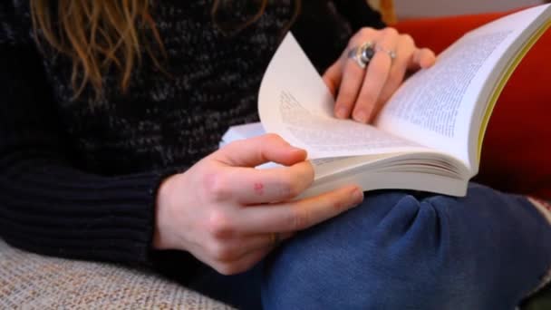 Девушка читает книгу в гостиной — стоковое видео