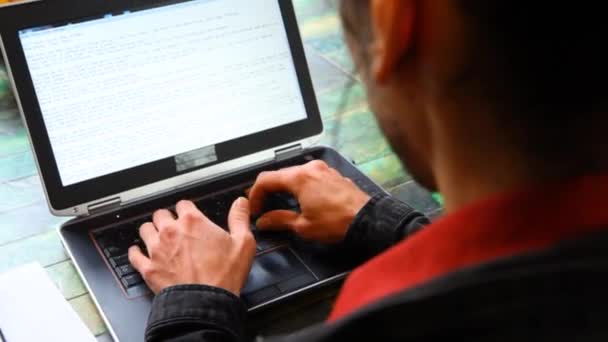 Man aan tafel werkt met laptop — Stockvideo