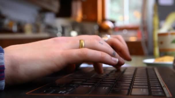 Jonge vrouw typt op een zwarte laptop — Stockvideo