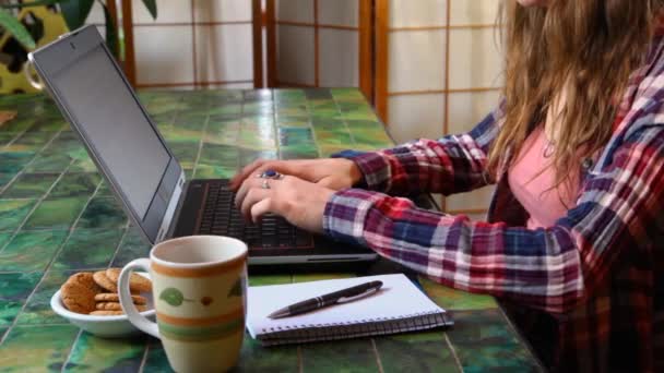 Жінка за столом працює з ноутбуком — стокове відео