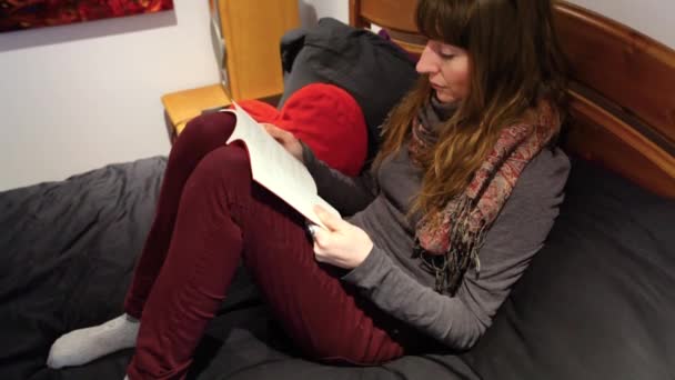 Girl reading in bedroom. — Stock Video