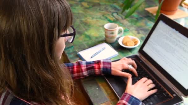 Vrouw aan tafel werkend met laptop — Stockvideo