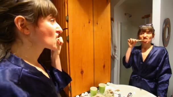 Дівчина чистить зуби у ванній . — стокове відео
