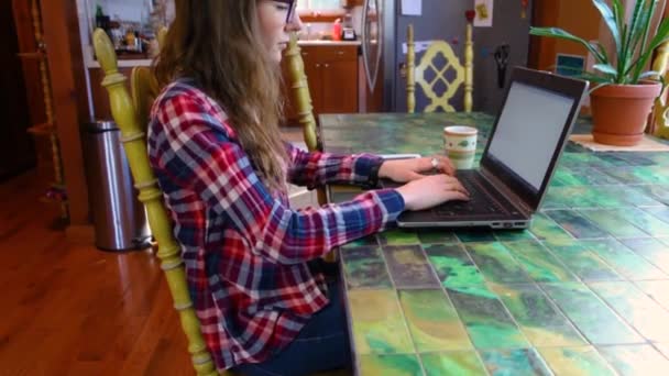 Vrouw aan tafel werkend met laptop — Stockvideo