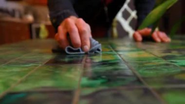 Adam masayı temizliyor.