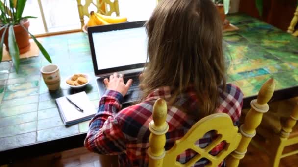 Kvinna vid bordet arbetar med bärbar dator — Stockvideo