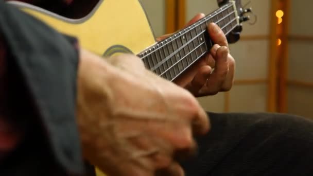 Hombre tocando música en un ukelele . — Vídeos de Stock
