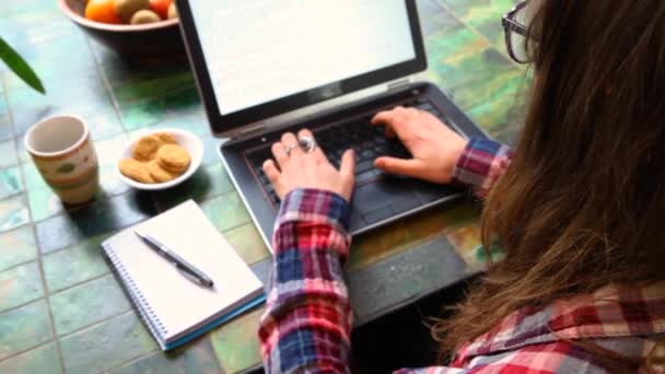 Vrouw aan tafel werkend met laptop — Stockvideo