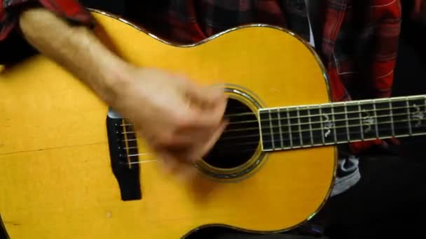 Man die op een akoestische gitaar tokkelt. — Stockvideo