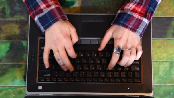 Νεαρή γυναίκα δακτυλογραφεί σε ένα μαύρο φορητό υπολογιστή — Αρχείο Βίντεο
