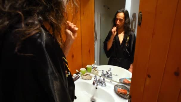 Чоловік чистить зуби у ванній . — стокове відео