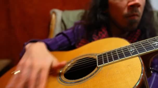 Mann spielt Gitarre im Wohnzimmer. — Stockvideo