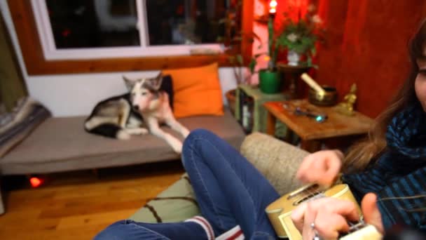 Girl playing ukulele in living room. — Stock Video