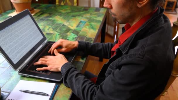 El hombre en la mesa está trabajando con el ordenador portátil — Vídeos de Stock