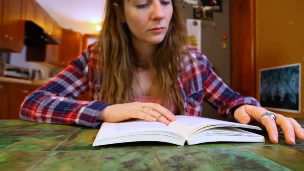 Mulher está lendo um livro na mesa — Vídeo de Stock