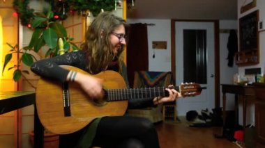 Kız evde klasik gitar çalıyor.