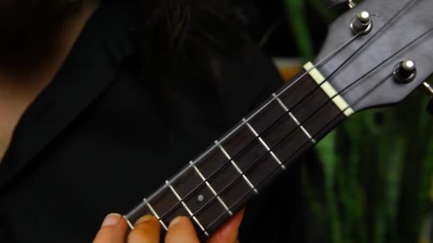 Young man is playing on a small ukulele — Stock Video