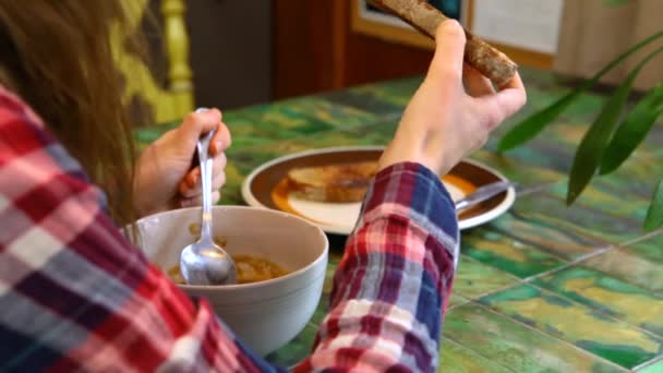 Chica comiendo sopa casera junto a la ventana — Vídeo de stock