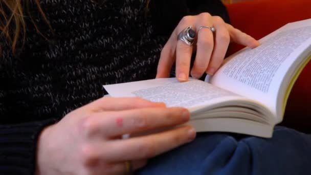Flicka läser en bok i ett vardagsrum — Stockvideo