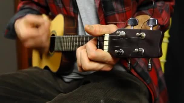 Hombre tocando música en un ukelele . — Vídeo de stock