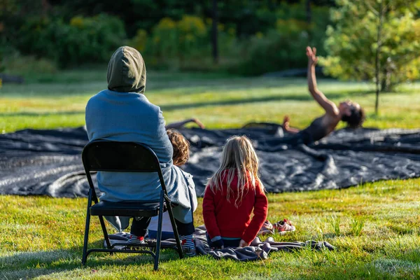 Família assistindo pessoas praticando ioga fora — Fotografia de Stock