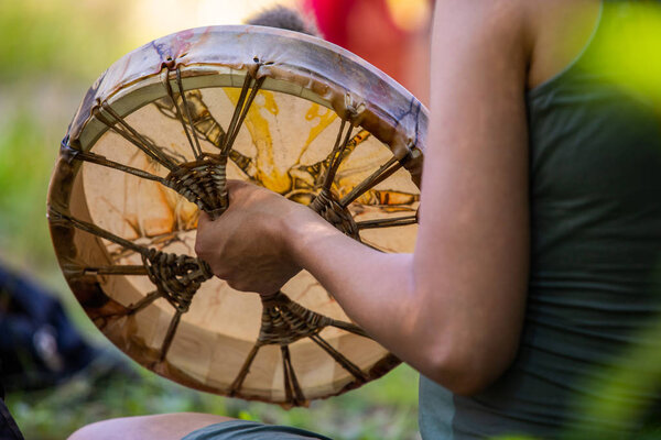 closeup on man playing on sacred drum