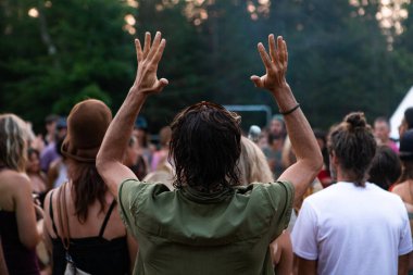 Festival adamı huşu içinde kollarını kaldırıyor.