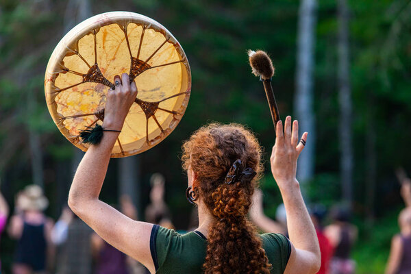 woman holding sacred drum in the sky