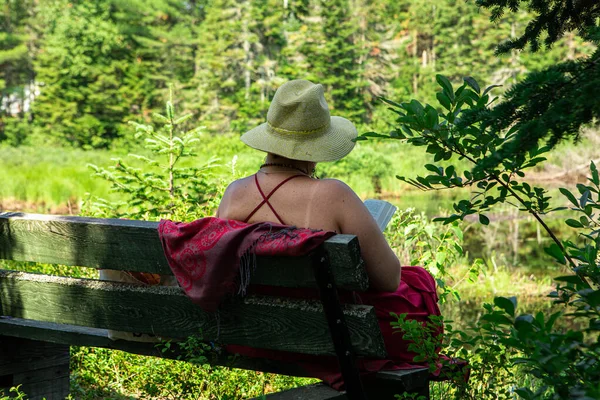 Mulher velha lendo um livro na natureza — Fotografia de Stock