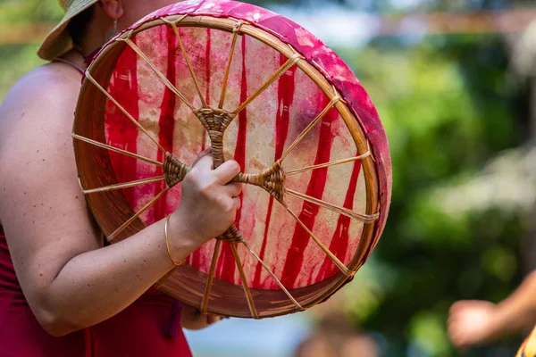 closeup of women playing sacred drum
