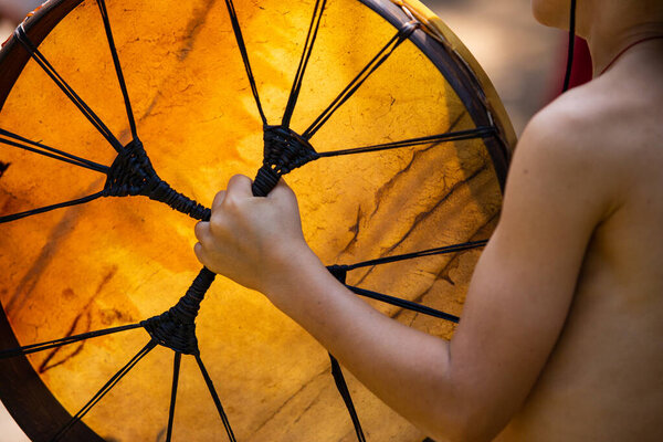 little kid holding native sacred drum