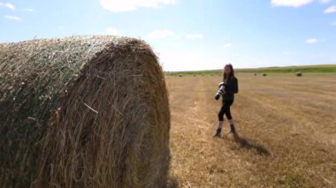 Kadın fotoğrafçı samanlıkta çekim yapıyor.