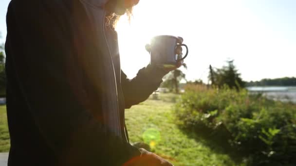 El hombre se sienta con el café de la mañana al aire libre — Vídeos de Stock