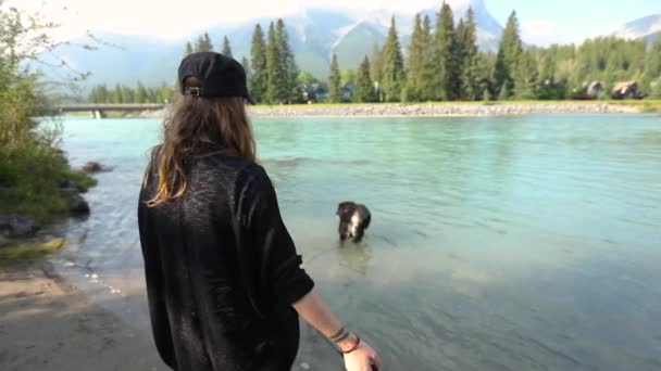 Mujer observa perro en el río de montaña — Vídeos de Stock