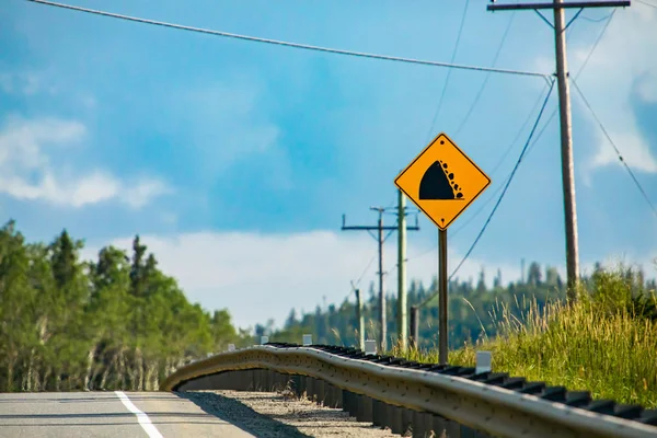 Следите за падающей скалой знак предупреждения дороги — стоковое фото