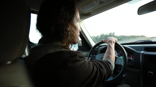 Hombre de pelo largo conduciendo por carretera — Vídeos de Stock