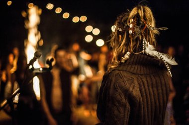 Genç şarkıcı gece kamp ateşi etrafında şarkı söylüyor..