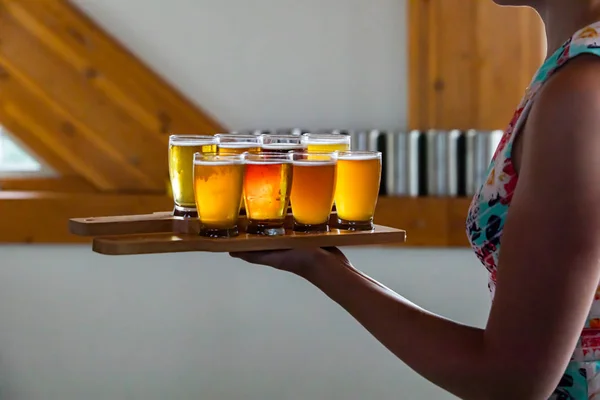 a woman serving holding beer trays