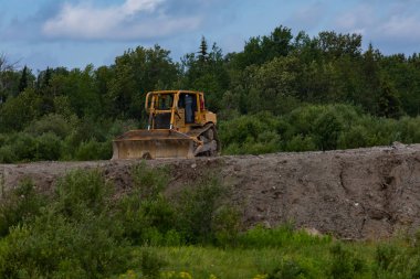 Toprak seti üzerine park edilmiş bir çiftlik aracı.
