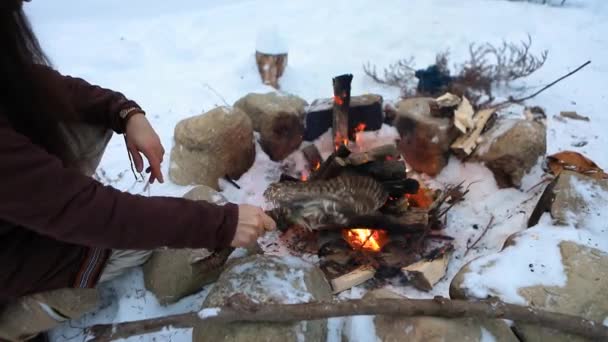 Inboorling stookt kampvuur in de winter — Stockvideo