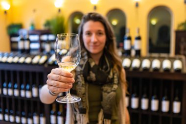 Kadın kameraya bakıyor ve kadeh kaldırıyor.