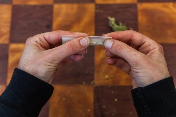 Рука раскатывает марихуану с нуля — стоковое фото
