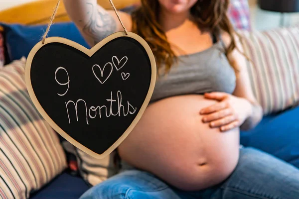 妊娠中の女性と9ヶ月のハートサイン — ストック写真