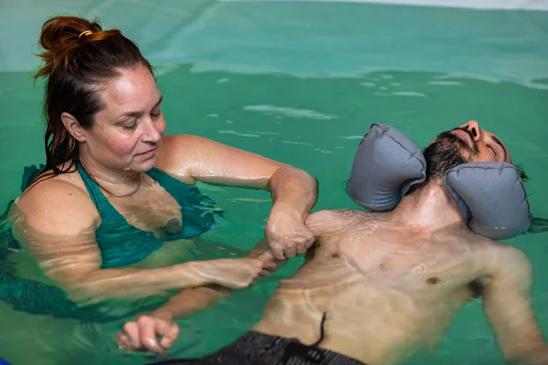 Homem recebendo massagem de mão na piscina — Fotografia de Stock