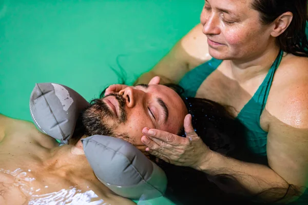 Man receiving facial water massage in pool — 스톡 사진