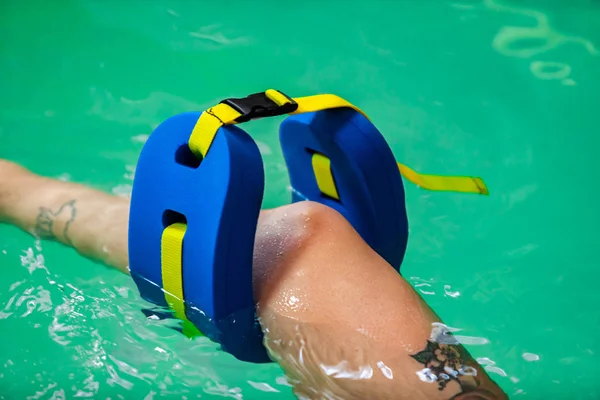 Perna das mulheres flutuando na água na piscina — Fotografia de Stock