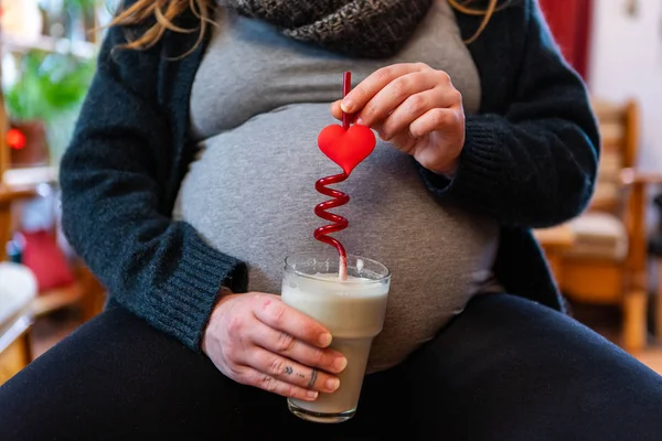Pregnant woman enjoys valentine drink
